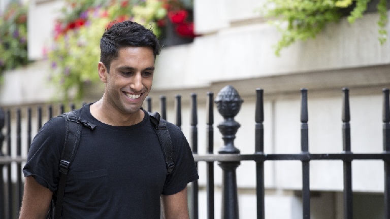 Amrik smiling walking down the street