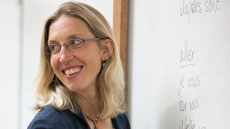 Sara sits on her sofa