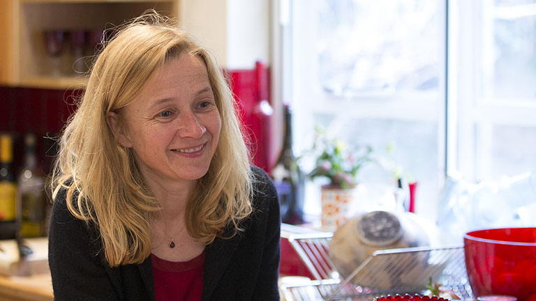 Lara smiles in her kitchen
