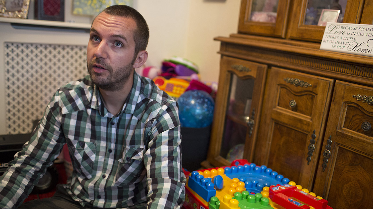 Luke sits on the floor crossed legged