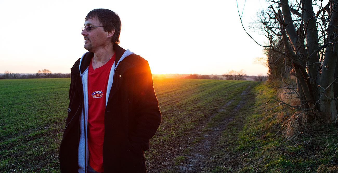 Paul on a walk in a field with the sun setting in the background