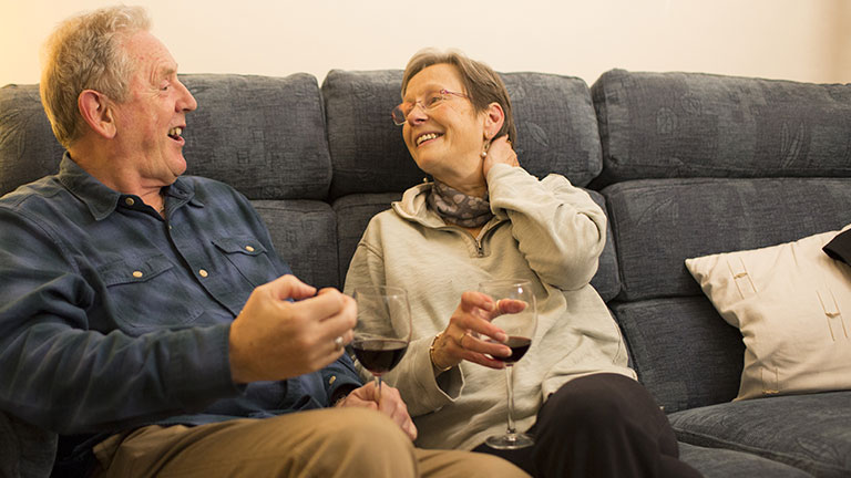 Dave has a glass of wine on the sofa with his partner Prue.