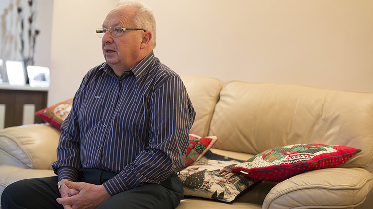 Bill sits on the sofa in his living room