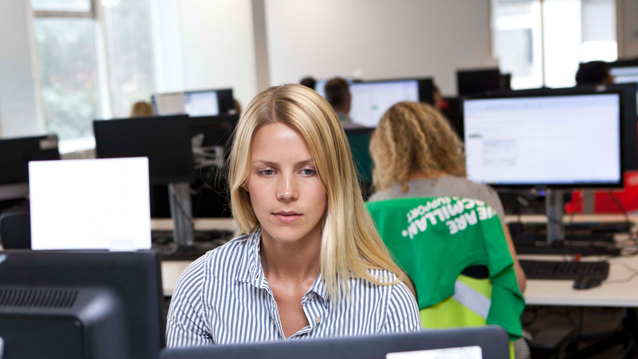 A Macmillan intern sits at a desk in an office.