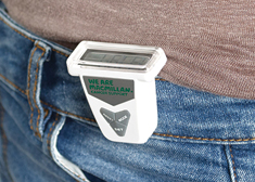 A white pedometer attached the the waistband of a pair of jeans.