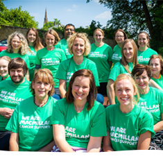 Supporters smiling, wearing green Macmillan t-shirts.