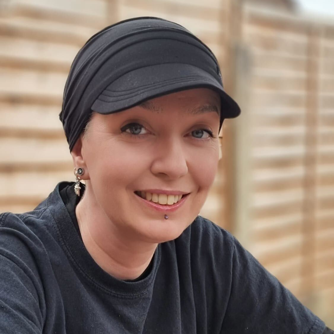 Sal, a woman wearing a black cap