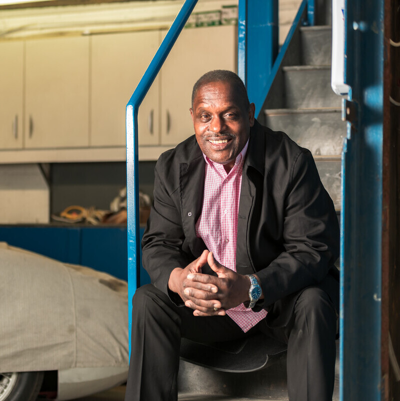 Errol, diagnosed with prostate cancer, sitting on some steps in a garage.