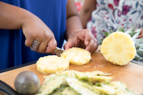 Lady chopping pineapple
