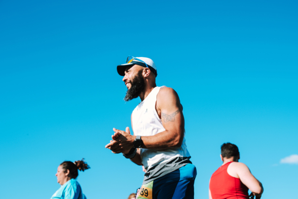 Three fundraisers running a relay on a sunny day