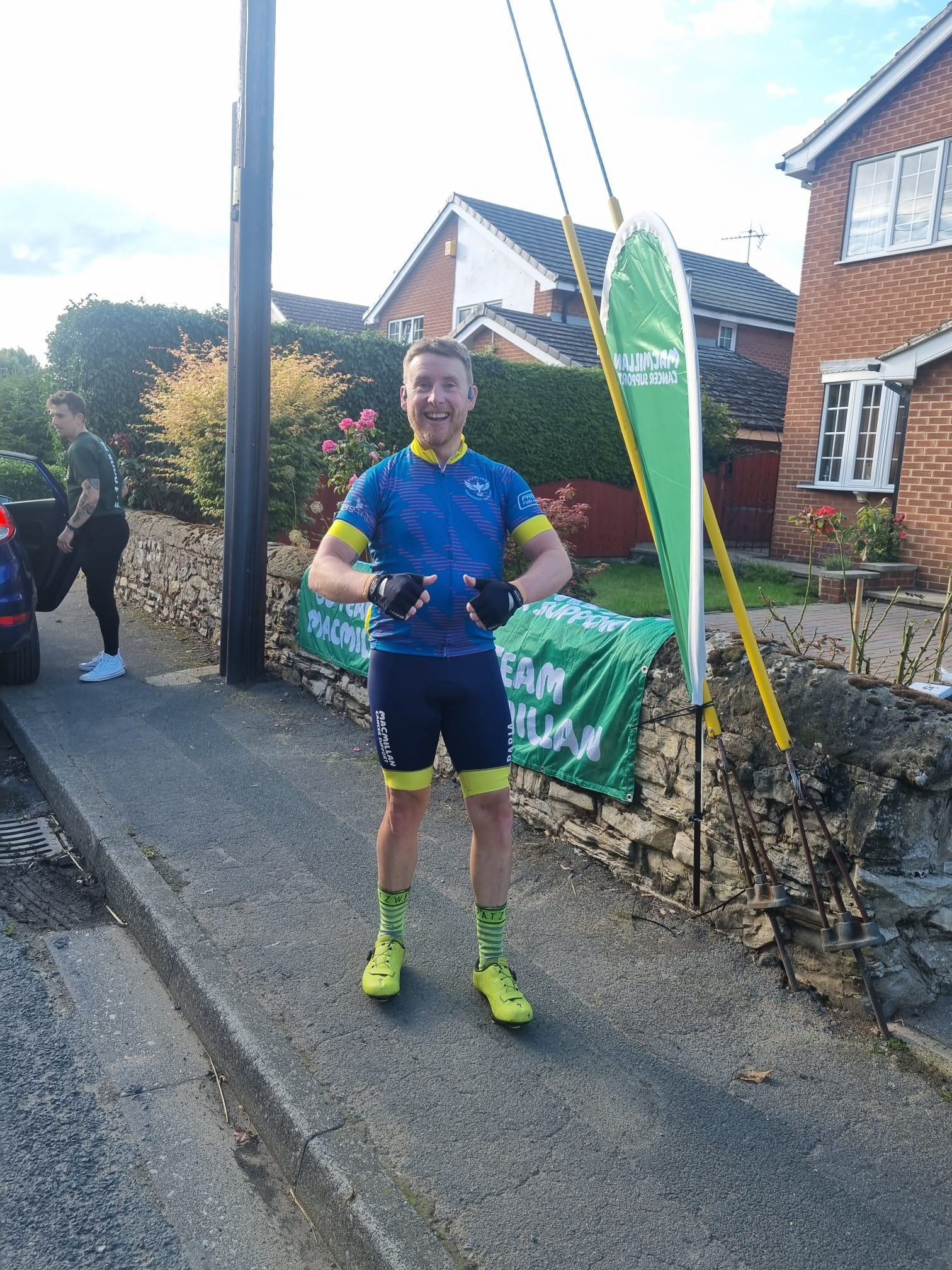Simon giving a thumbs up off of the bike on the pavement 
