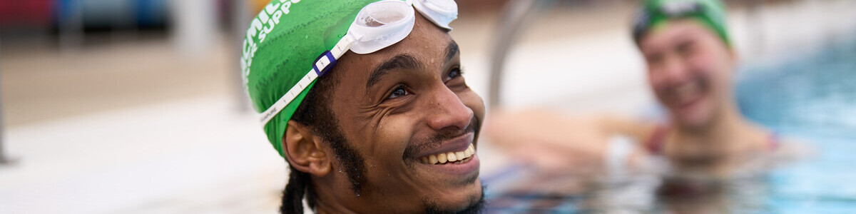 A young black man is in a swimming pool.