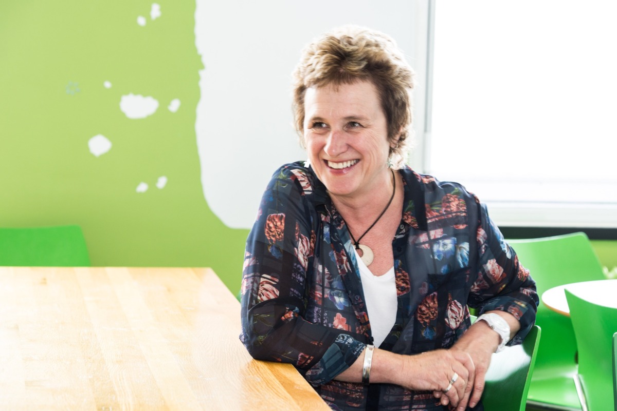 Joelle sits at a desk smiling at something off camera.