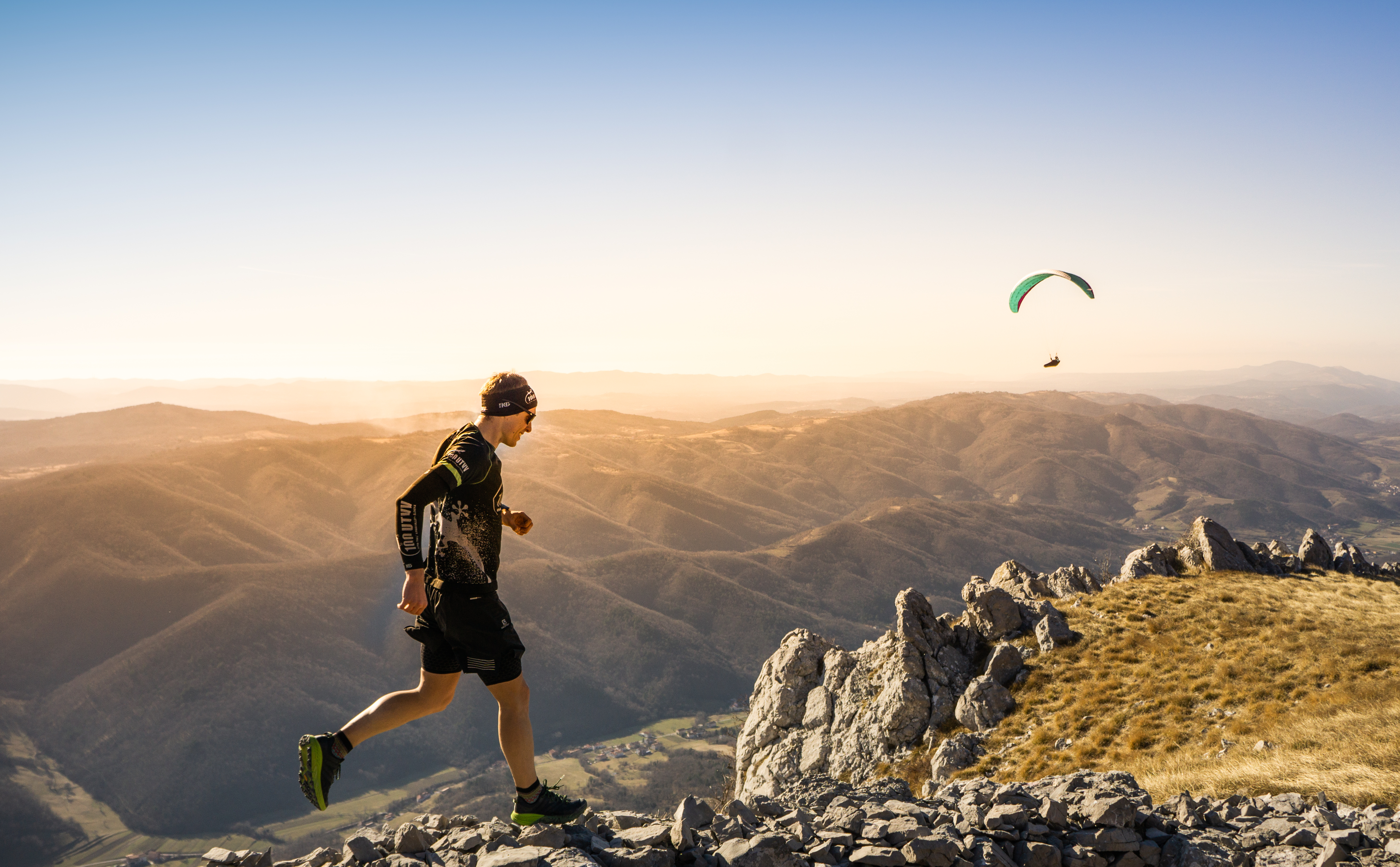 An Ultra X series competitor running on hilly, mountainous terrain.