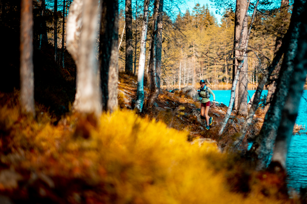 A Ultra X series competitor running through woodland.