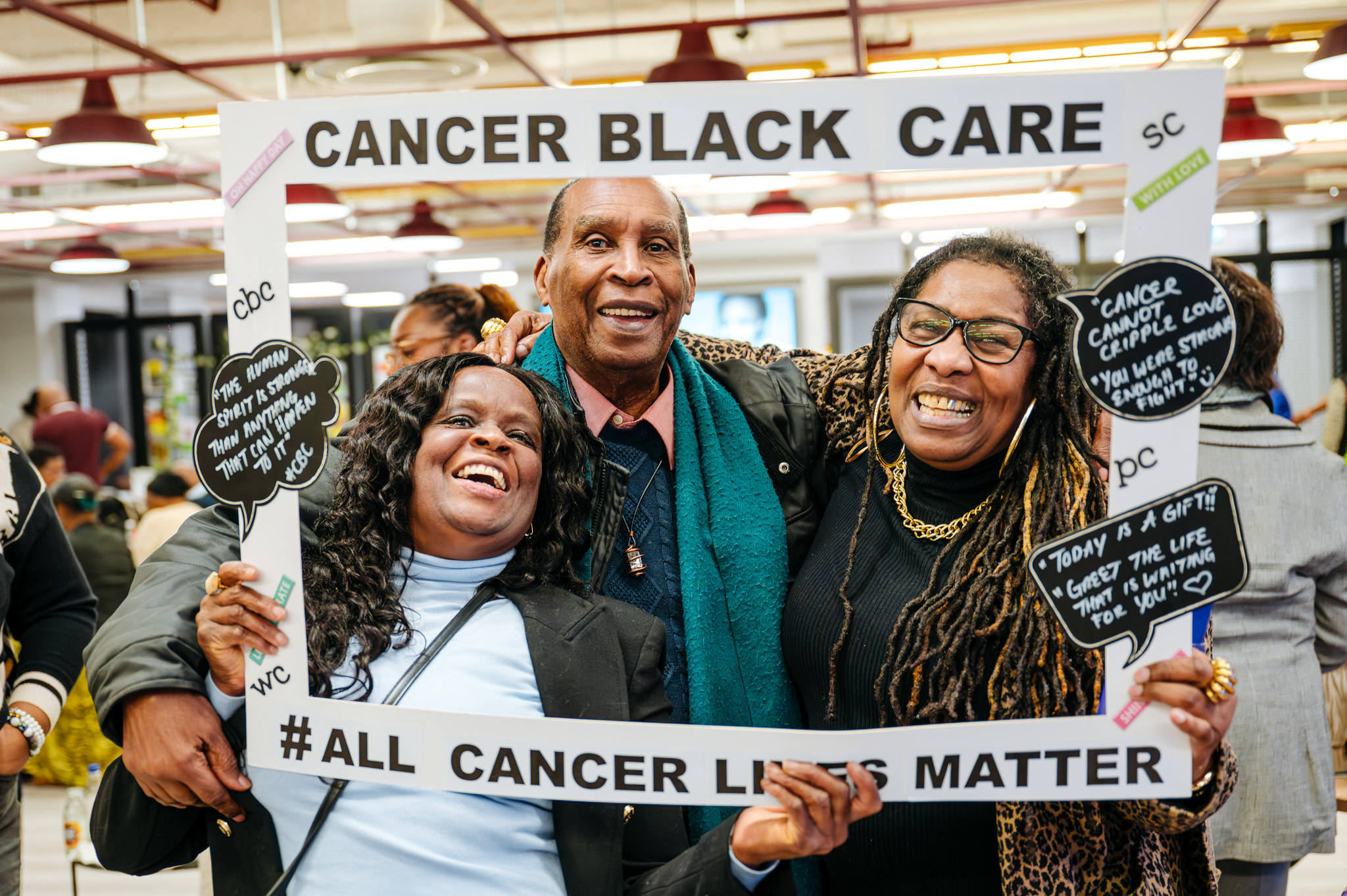3 black people are smiling with a cancer black care banner.