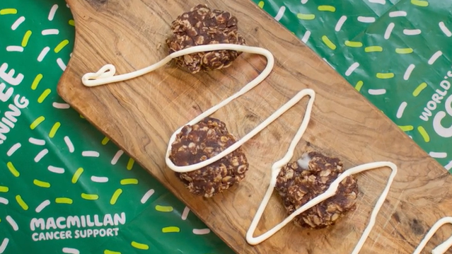 Cookies with coconut cream drizzled on top on a wooden board