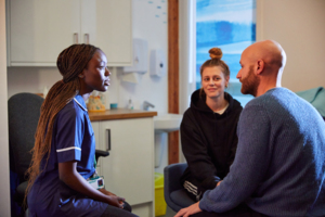 A nurse speaks to a male and female patient.
