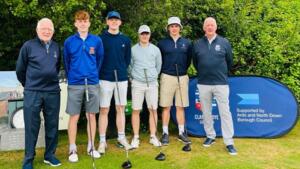 The bogeymen are standing together in a line with 2 other individuals. They appear to be outside and are standing with their golf clubs.