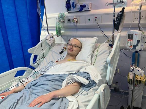 Jonny is in his twenties and is lying in a hospital bed.