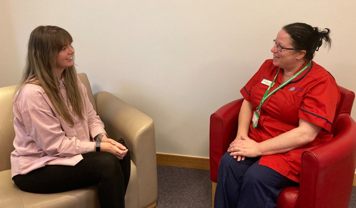 Macmillan palliative care team member talking to a lady.