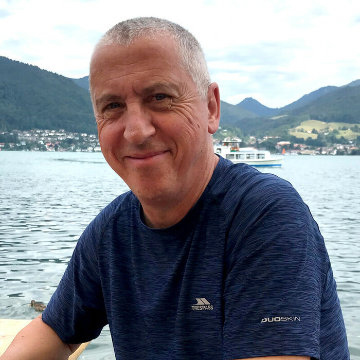 Joe smiling in front of a lake