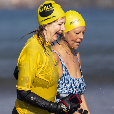 Ellie Ricketts in wetsuit and swimming cap with a fellow swimmer