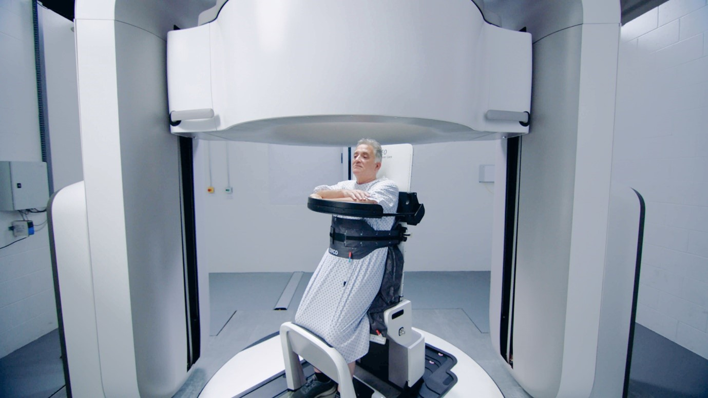 Someone using the upright radiotherapy machine