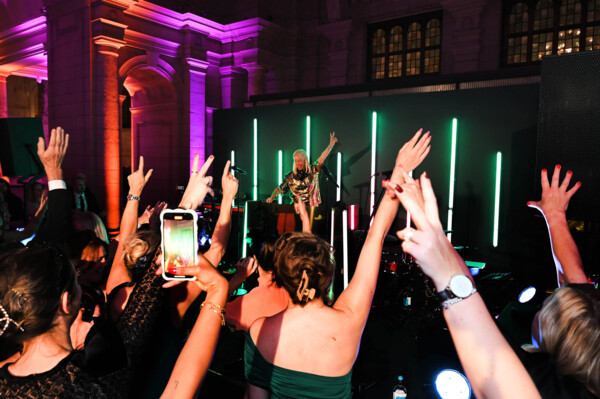 People dancing with their hands in the air as Denise van Outen is DJing at the Macmillan Ball