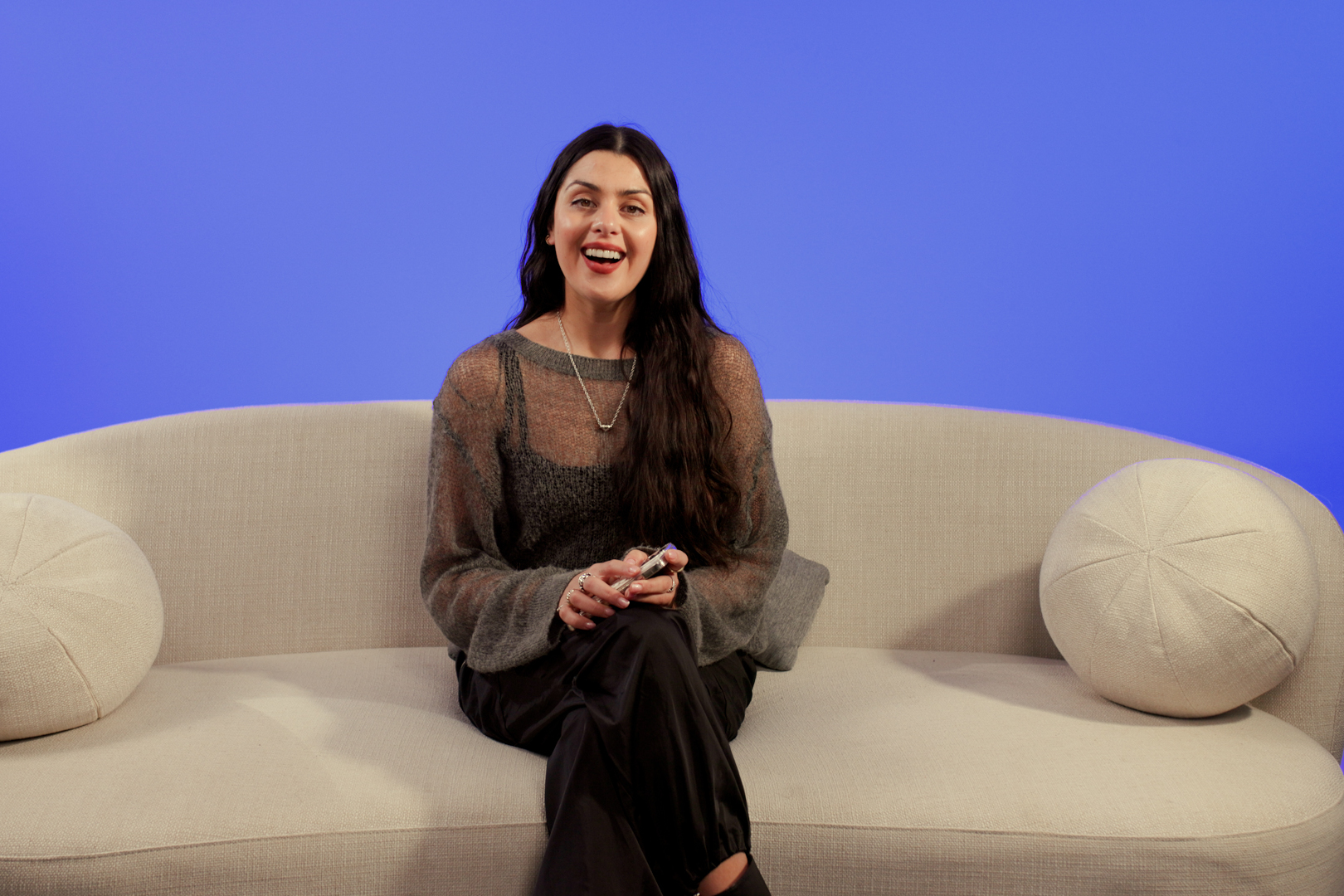 Lauren, a young woman with long dark brown hair sat on a sofa.
