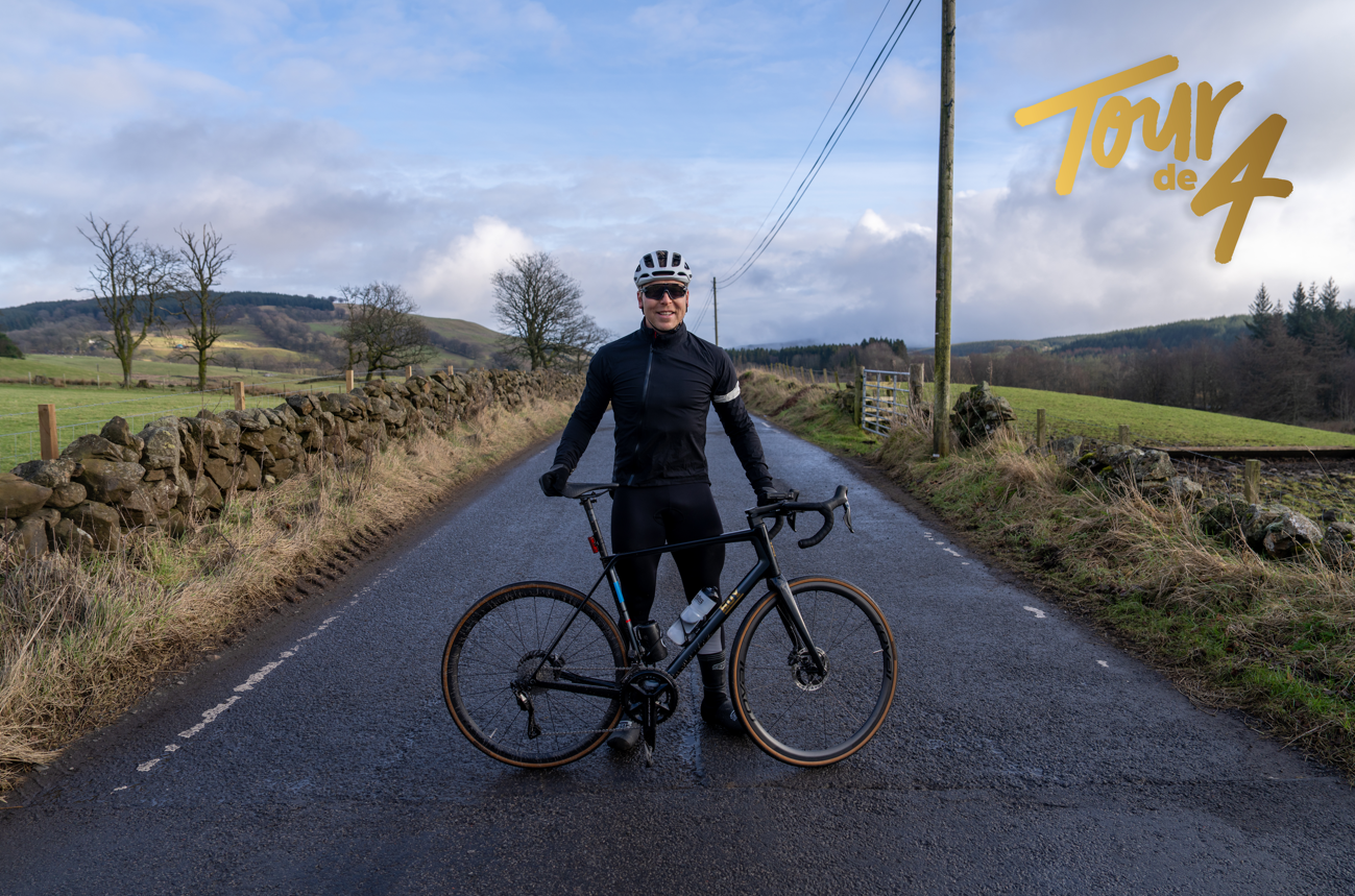 Sir Chris Hoy standing with his bike on the road