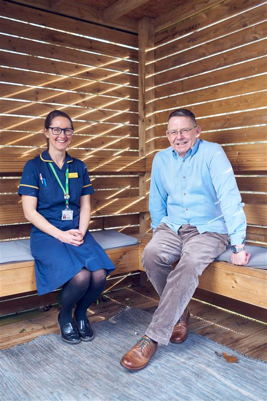 Macmillan nurse Nicky sat talking to someone 