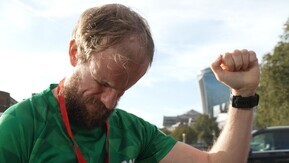 A man with a beard wearing a Macmillan t-shirt after a run.
