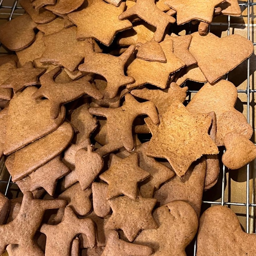 A baking cool rack has pepperkakor cookies on them.