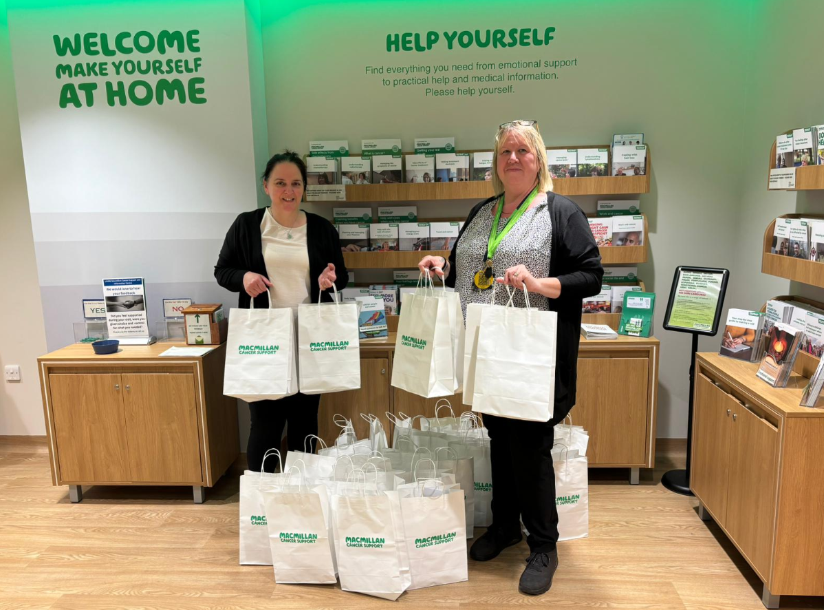 Two volunteers at a Welcome Break Macmillan support stand