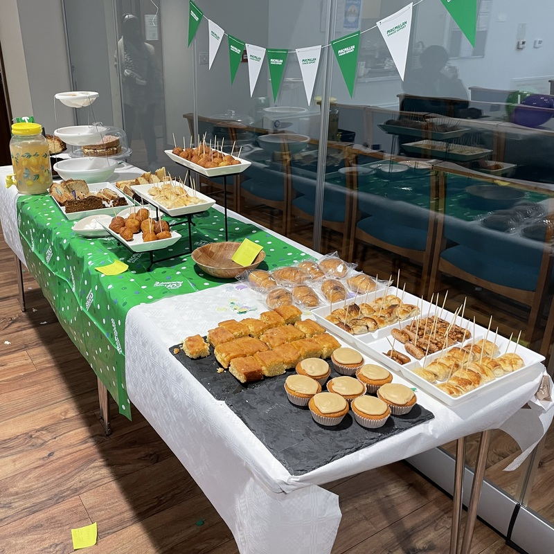 A table is decorated for a Coffee Morning at the Hackney Stoke Newington Methodist Church. It has many different dishes on it.
