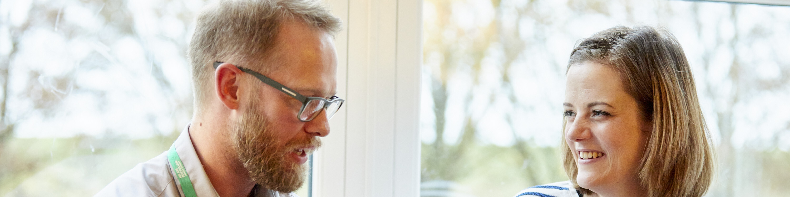 A Macmillan nurse and his patient are talking and smiling together