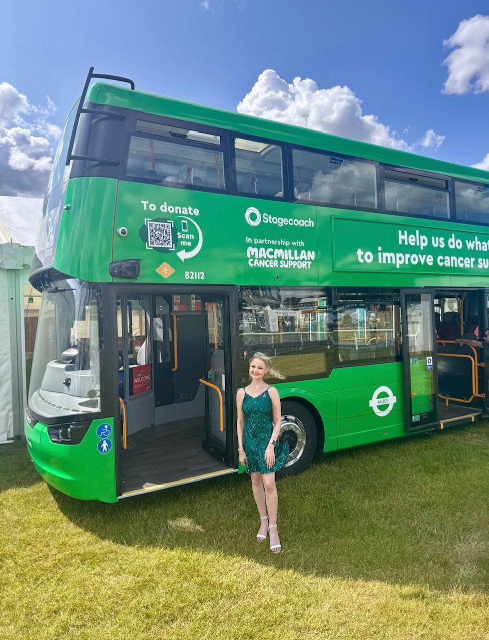 Kimberley in front of a Macmillan double decker bus
