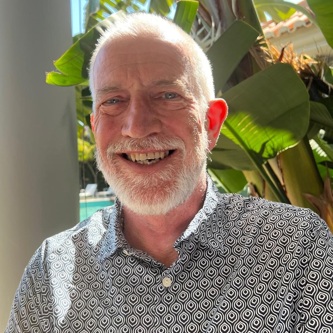 A white man with grey short hair and a beard.