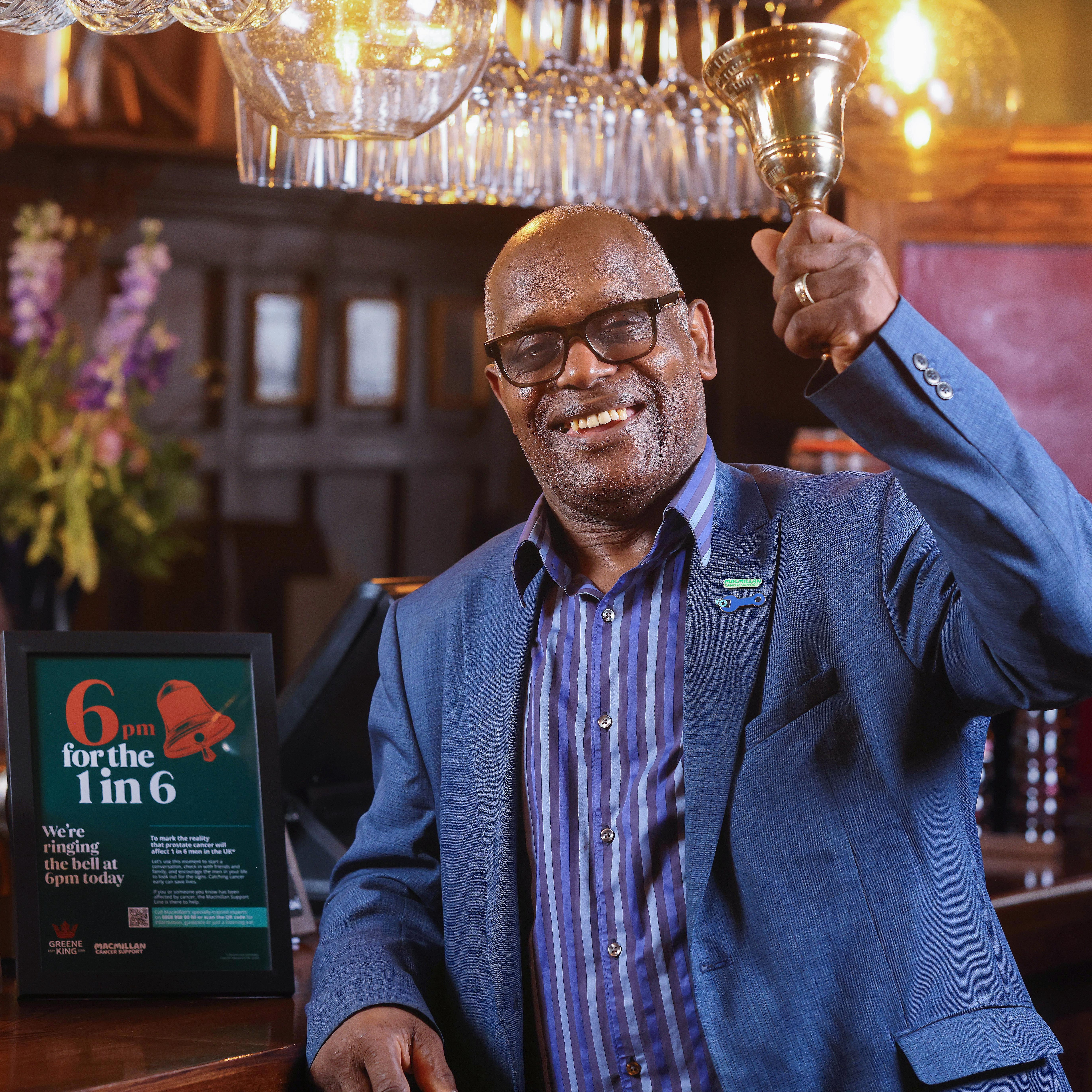 Errol is a Black man ringing a pub last orders bell.