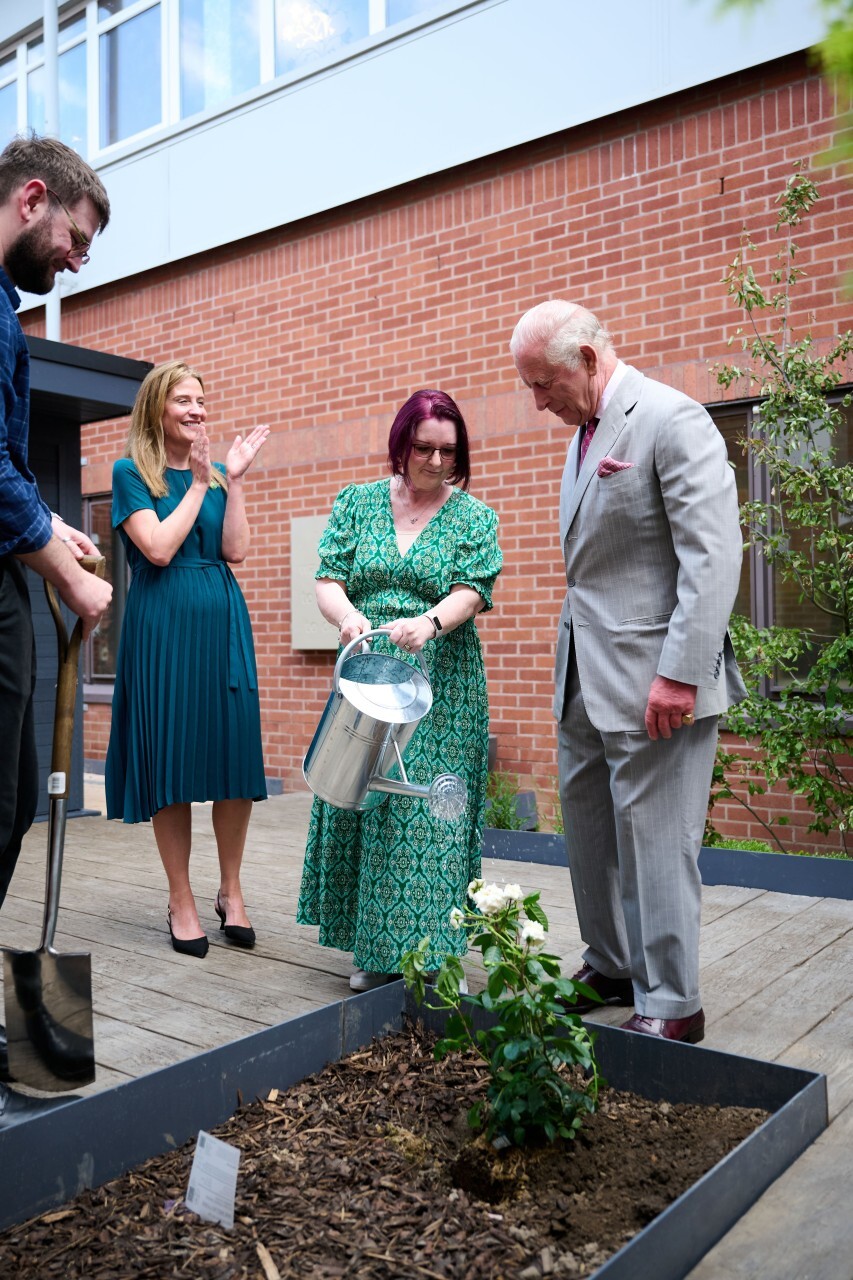 His Majesty planting a Macmillan Rose with Angie Lunt Community Engagement Volunteer at Sir Robert Ogden Macmillan Cancer Care Centre in York