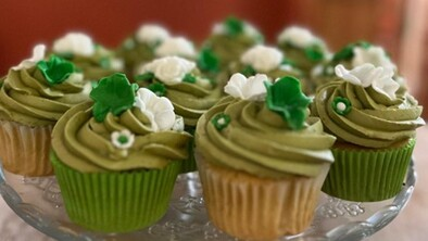 Vanilla cupcakes with rich, matcha buttercream frosting. They have been decorated with different green and white flower details.