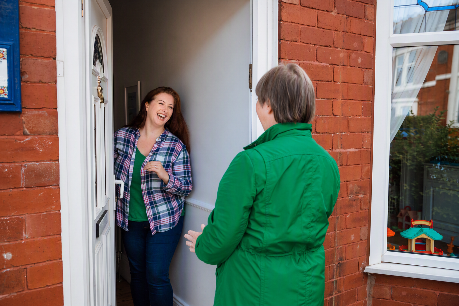 A lady opening a door to a Macmillan fundraiser.