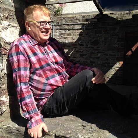 A man in a red checked shirt wearing glasses.
