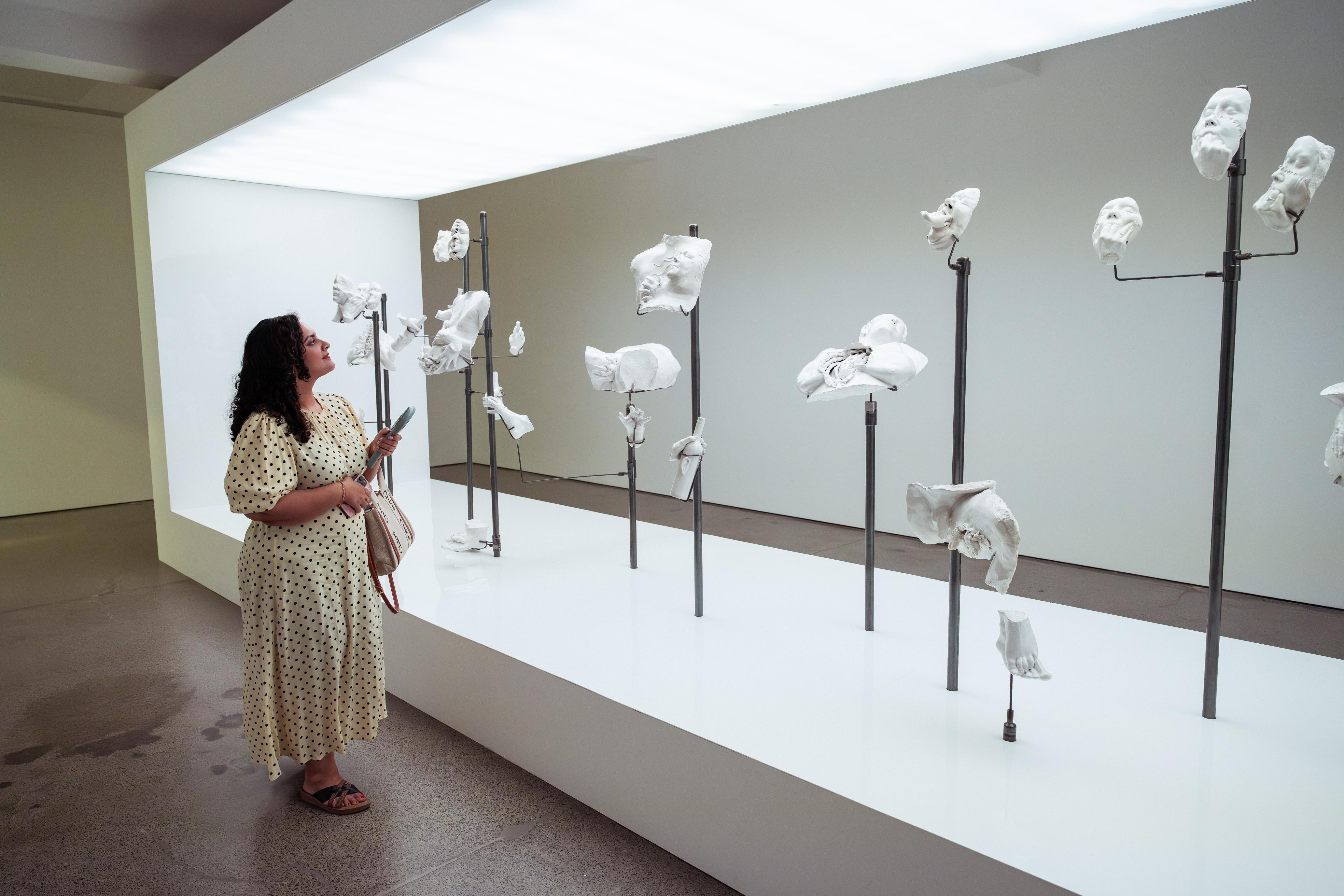 A woman looking at an art installation 