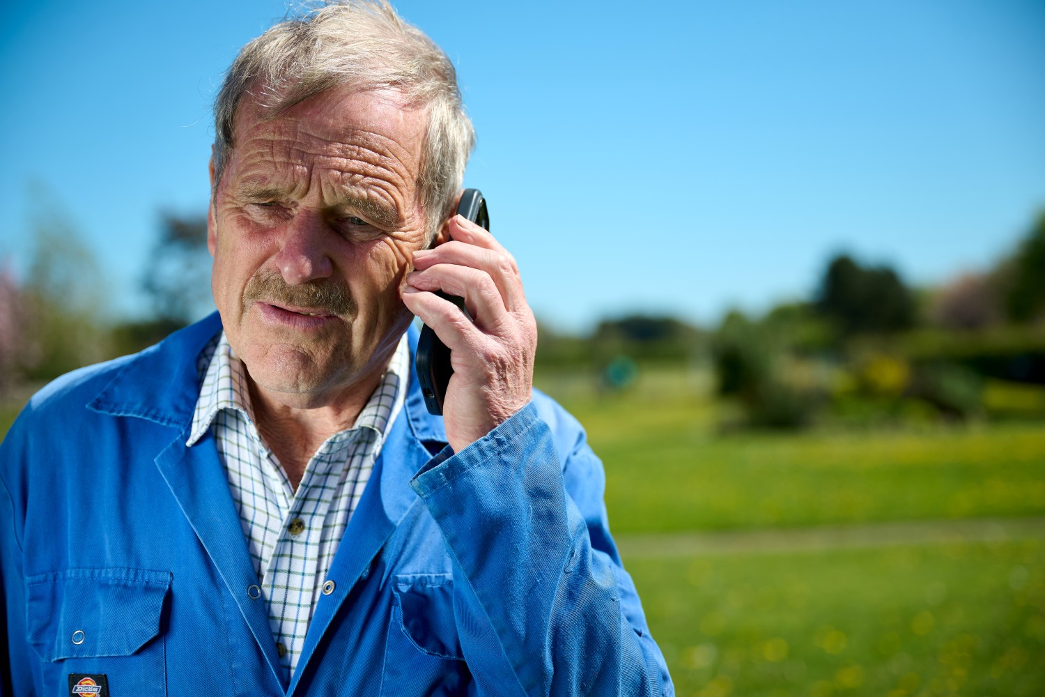 Denys on the phone in a field