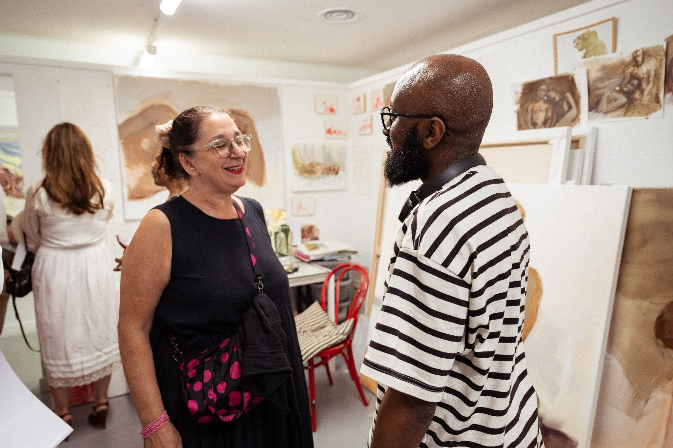 A man and a woman talking in an art gallery