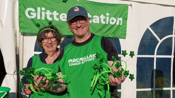 Two volunteers at a Mighty Hike are passing out celebratory green star-themed headbands.