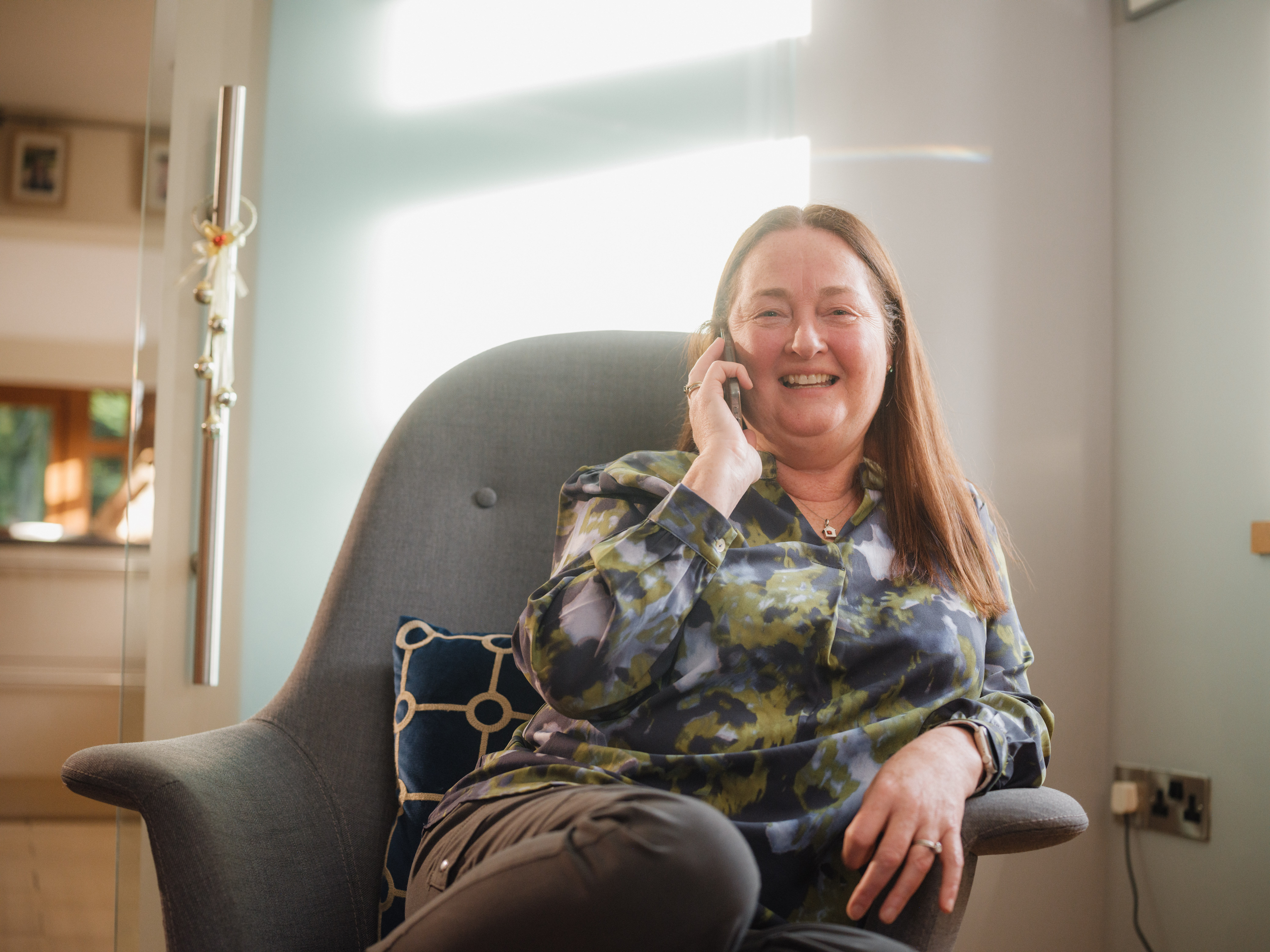 Bernie, a lady sat on a chair on the phone.