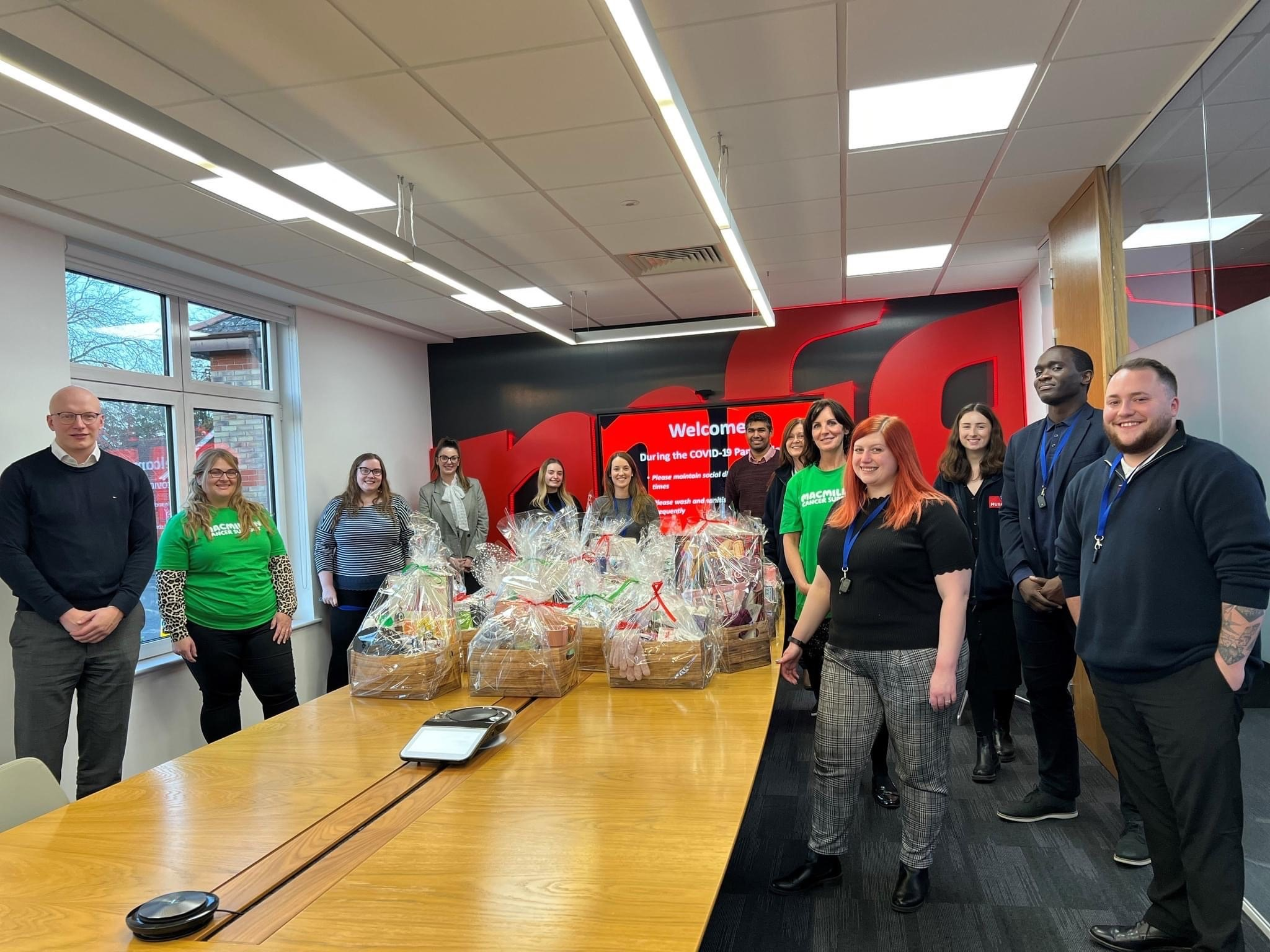 Staff of the Motor Fuel Group in a meeting room with hampers on the table